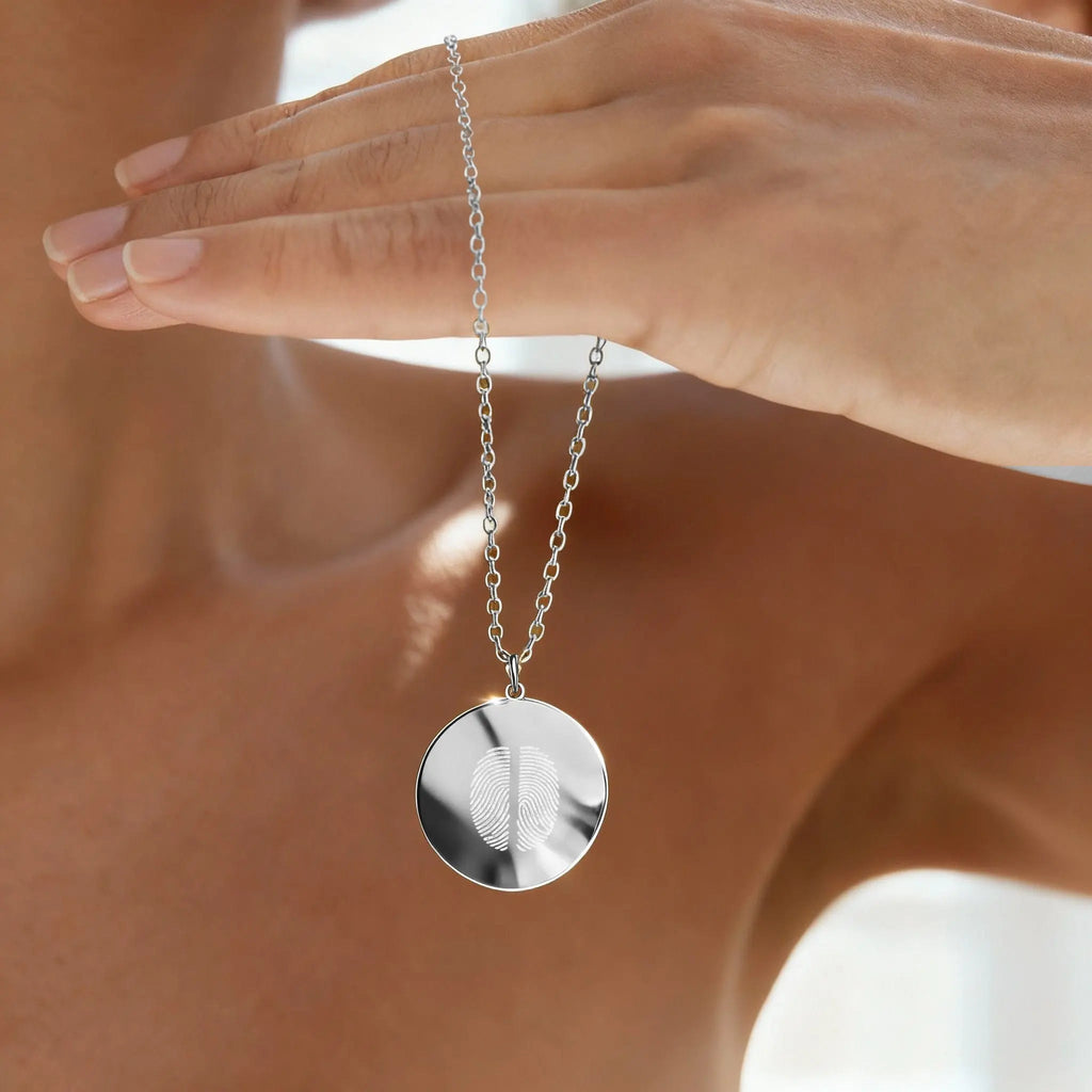Model holding the Atelier Two Fingerprint Pendant Necklace in 925 Sterling Silver, showing its reflective finish and intricate dual fingerprint engraving — a luxurious keepsake symbolizing lasting love and connection.