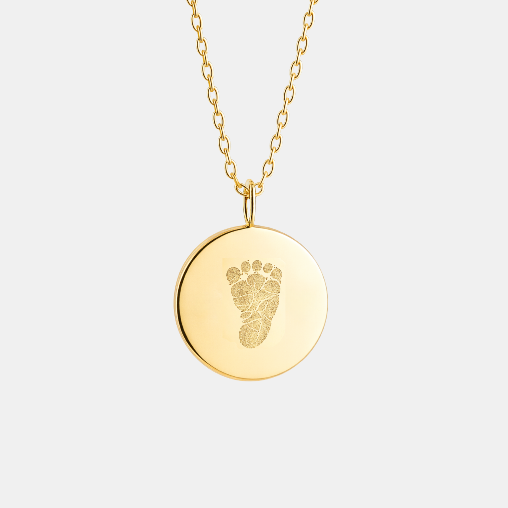 Custom engraved 18k gold vermeil 16mm coin pendant necklace on diamond-cut cable chain, featuring a personalised single newborn baby footprint with intricate toe and sole detail precision diamond-head engraved on warm high-polish gold disc – Atelier By Dsgn luxury custom footprint coin necklace meaningful gift for new mum, new dad, mothers day, fathers day, baby shower, birth announcement or treasured newborn heirloom necklace