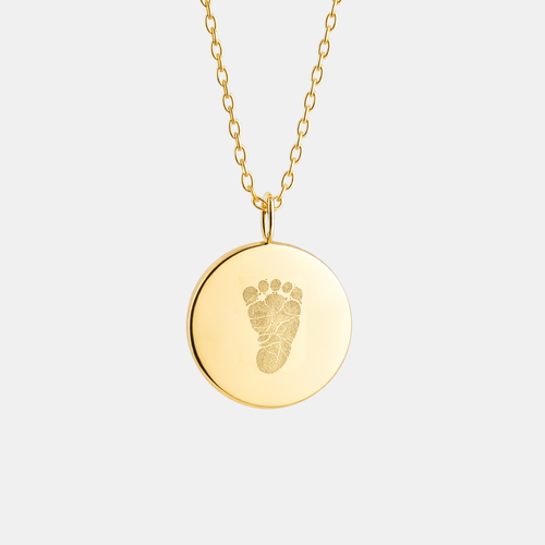 Custom engraved 18k gold vermeil 16mm coin pendant necklace on diamond-cut cable chain, featuring a personalised single newborn baby footprint with intricate toe and sole detail precision diamond-head engraved on warm high-polish gold disc – Atelier By Dsgn luxury custom footprint coin necklace meaningful gift for new mum, new dad, mothers day, fathers day, baby shower, birth announcement or treasured newborn heirloom necklace