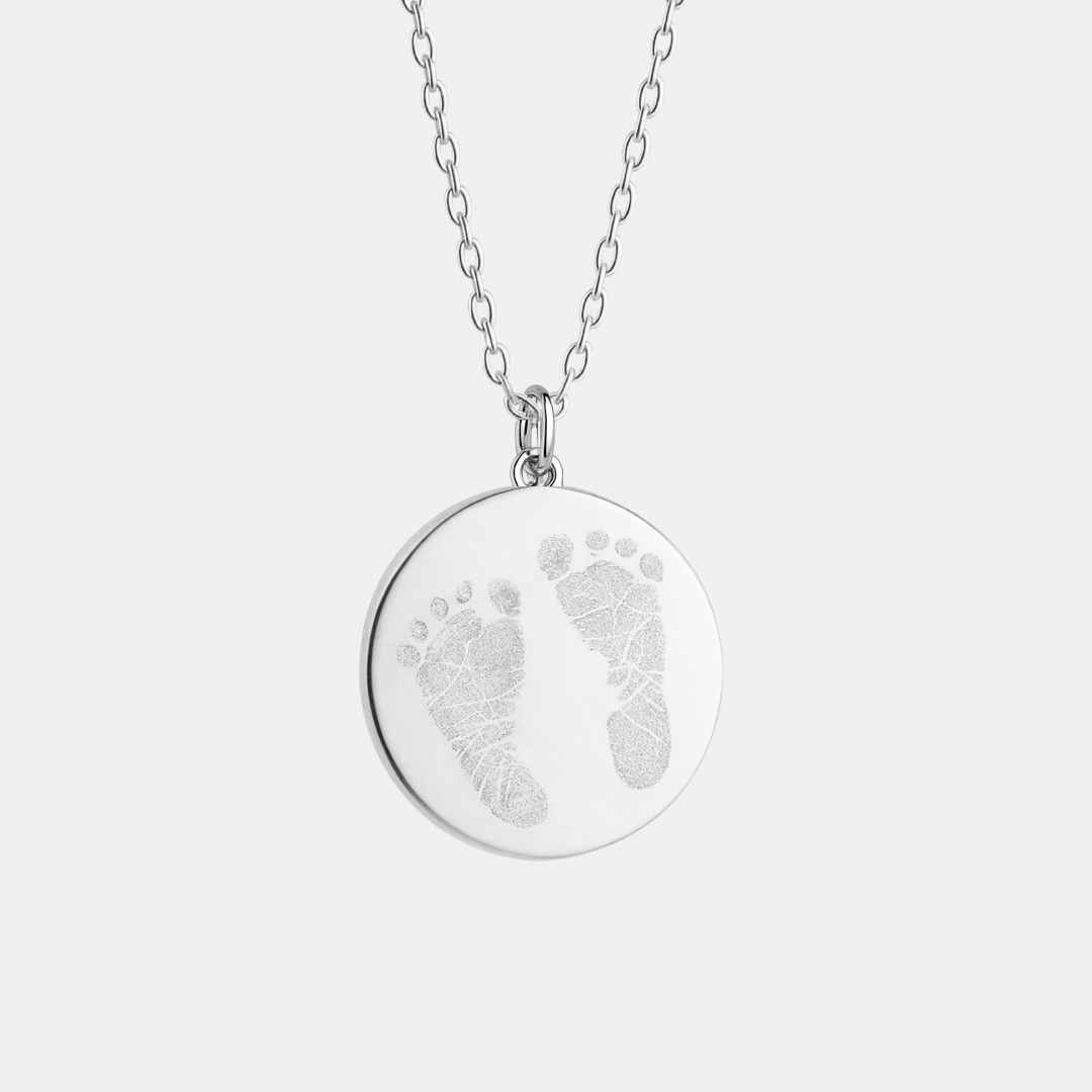 Custom engraved 925 sterling silver 16mm coin pendant necklace on diamond-cut cable chain, featuring personalised double newborn baby footprints with intricate toe and sole detail precision diamond-head engraved on polished round disc – Atelier By Dsgn custom footprint pendant jewellery meaningful gift for new mum, new dad, mothers day, fathers day, baby shower, birth announcement or treasured newborn keepsake necklace