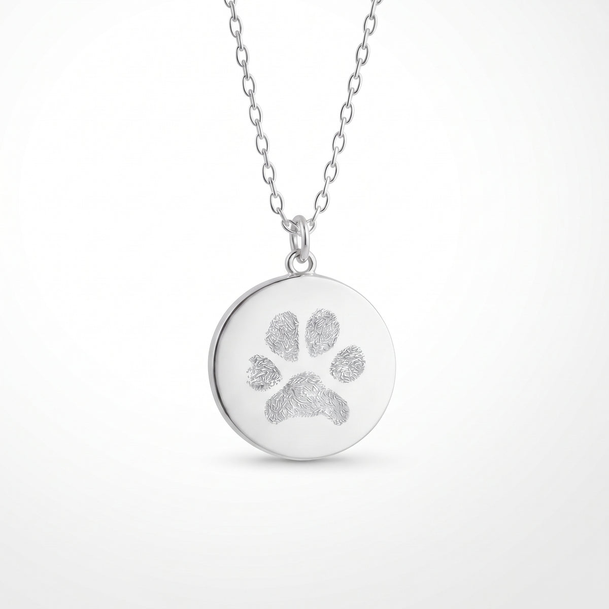 Custom engraved 925 sterling silver 16mm coin pendant necklace on diamond-cut cable chain, featuring a personalised pet paw print with intricate toe and pad texture detail precision diamond-head engraved on polished round disc.  Atelier By Dsgn custom paw print pendant jewellery meaningful gift for dog lovers, cat lovers, pet mum, pet dad, pet memorial, rainbow bridge remembrance or new pet adoption keepsake necklace.  Atelier By DSGN