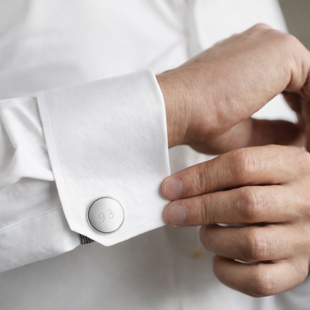 Groom fastening custom engraved 925 sterling silver round cufflink on white dress shirt cuff, personalised number "93" precision diamond-head engraved on polished silver face - Atelier By Dsgn personalised text cufflinks meaningful gift for groom, wedding day, groomsmen, fathers day or significant number and date milestone keepsake mens jewellery