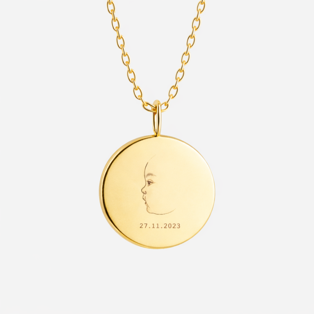 Custom engraved 18k gold vermeil 16mm coin pendant necklace on diamond-cut cable chain, featuring a personalised single-line minimalist newborn baby side profile portrait with birth date "27.11.2023" precision diamond-head engraved on warm high-polish gold disc – Atelier By Dsgn luxury custom baby portrait jewellery meaningful gift for new mum, mothers day, baby shower, birth announcement or treasured newborn keepsake necklace