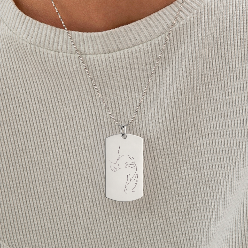 Custom engraved 925 sterling silver single-line drawing dog tag necklace worn on female model in cream ribbed top, personalised minimalist mother and newborn baby portrait precision diamond-head engraved on polished silver tag on 61cm bead chain – Atelier By Dsgn custom portrait jewellery meaningful gift for new mum, mothers day, baby shower or cherished birth keepsake necklace