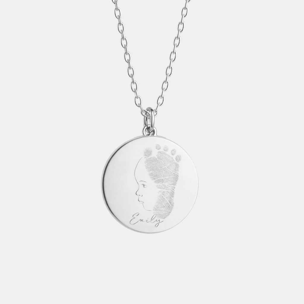 Custom engraved 925 sterling silver 16mm coin pendant necklace on diamond-cut cable chain, featuring personalised single-line minimalist baby side profile portrait uniquely fused with actual baby footprint texture and handwritten name "Emily" precision diamond-head engraved on polished round disc – Atelier By Dsgn custom fingerprint footprint baby portrait jewellery meaningful gift for new mum, mothers day, baby shower, birth announcement or treasured newborn keepsake necklace