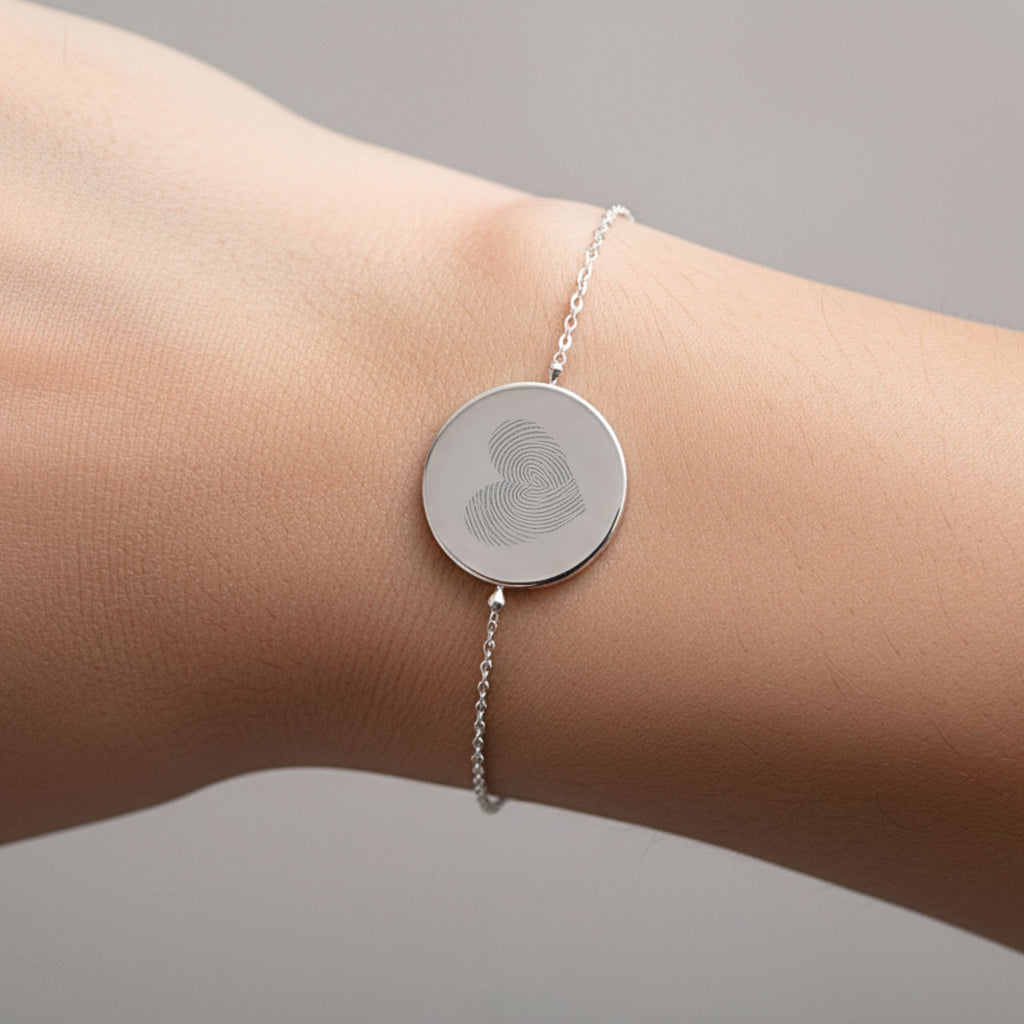 Heart fingerprint coin bracelet in 925 sterling silver worn on a wrist, showcasing unique design by Atelier.