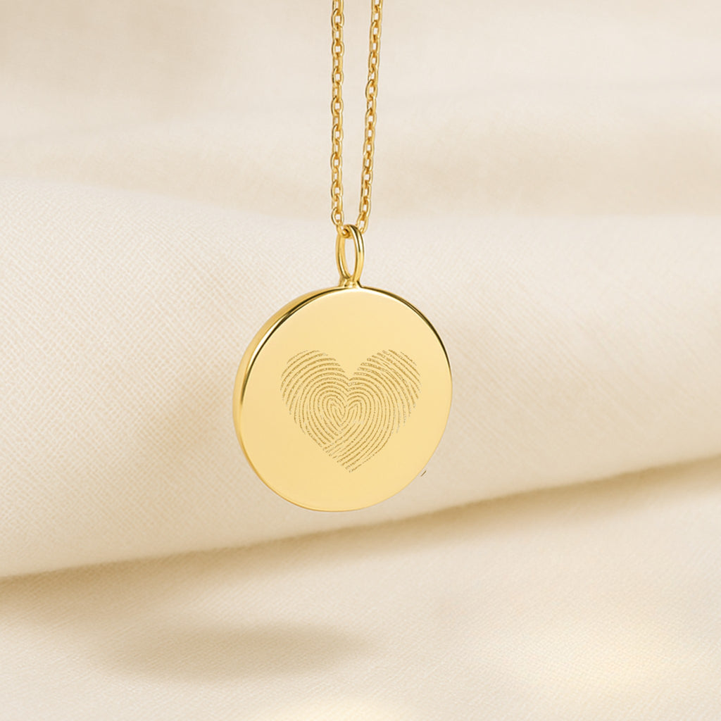 Elegant Heart Fingerprint Pendant Necklace in 18K Gold Vermeil by Atelier resting on soft cream fabric. Features two fingerprints forming a heart design, symbolising love, unity, and connection. A luxury personalised keepsake necklace crafted with timeless minimalism and fine detail.