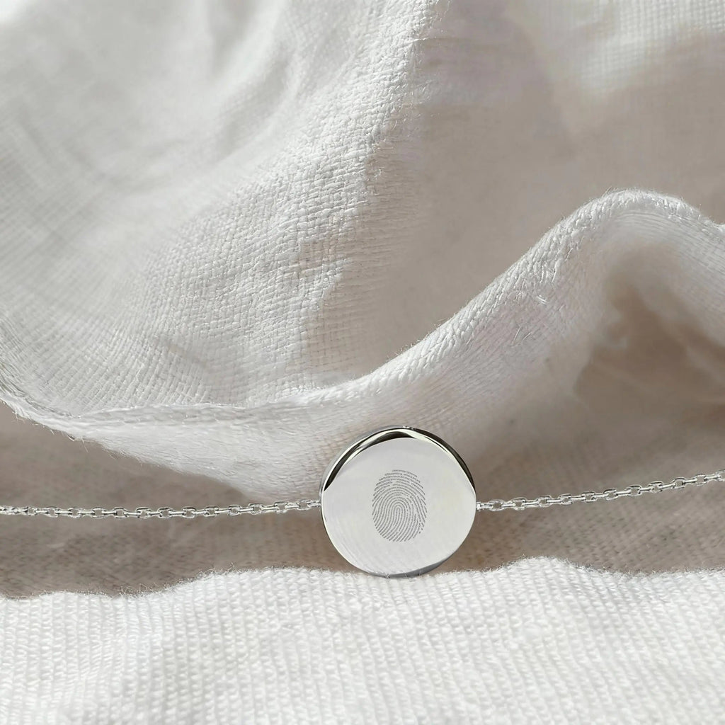 Single fingerprint coin bracelet in 925 sterling silver by Atelier By DSGN showcasing a flatlay view of the intricate design.