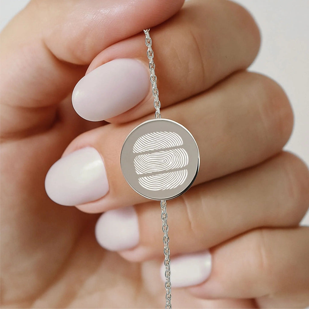 Close-up of Atelier By DSGN three fingerprint coin bracelet in 925 sterling silver, showcasing intricate design and craftsmanship.