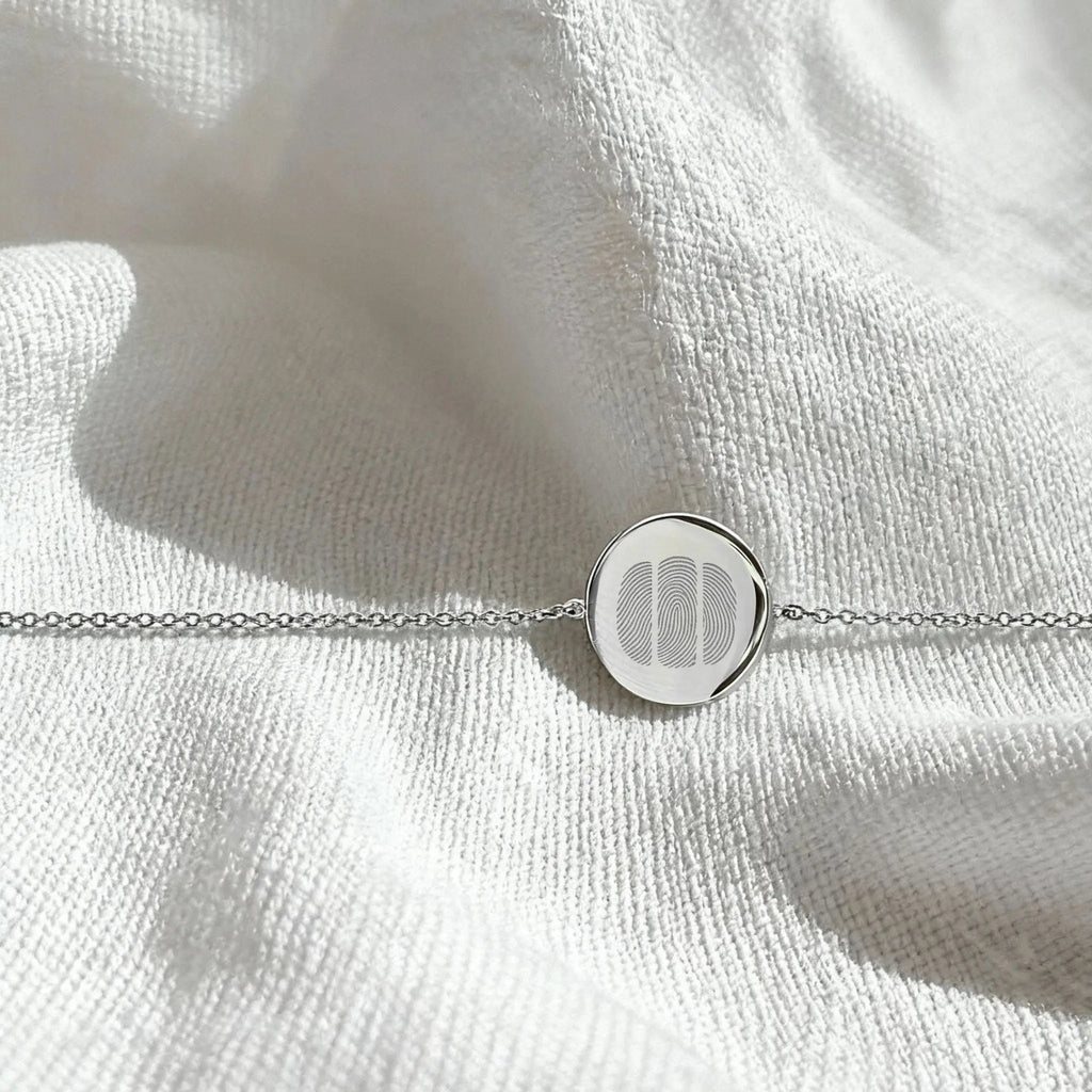 Three Fingerprint Coin Bracelet in 925 Sterling Silver by Atelier By DSGN, displayed in a flatlay arrangement.