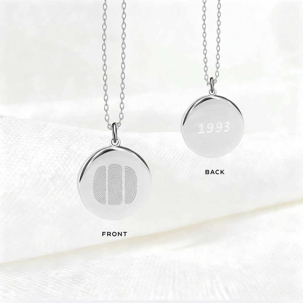 Front and back view of the Atelier By DSGN Three Fingerprint Pendant Necklace in 925 Sterling Silver, featuring three engraved fingerprints on the front and personalized engraving with the year “1993” on the back - a meaningful custom keepsake of love and family.