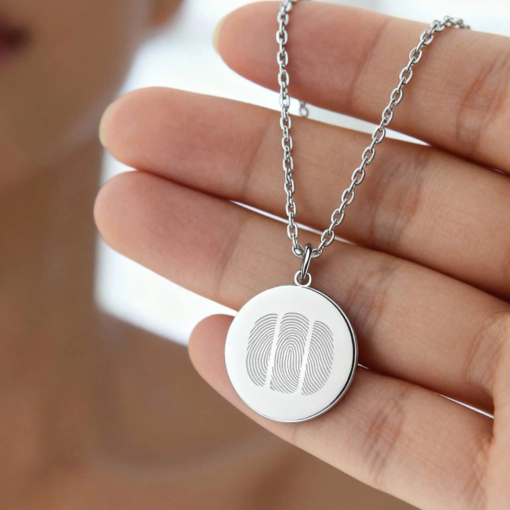 Close-up of the Atelier By DSGN Three Fingerprint Pendant Necklace in 925 Sterling Silver, showing three precisely engraved fingerprints on a polished coin pendant — a handcrafted piece symbolizing family, unity, and enduring love.