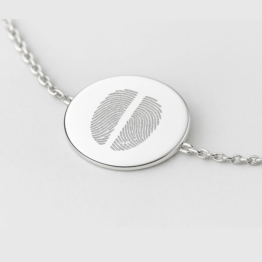 Close-up of the Atelier By DSGN Two Fingerprint Coin Bracelet in 925 Sterling Silver, showing a detailed view of the polished 16mm pendant engraved with two fingerprints, highlighting fine craftsmanship and elegant chain links.