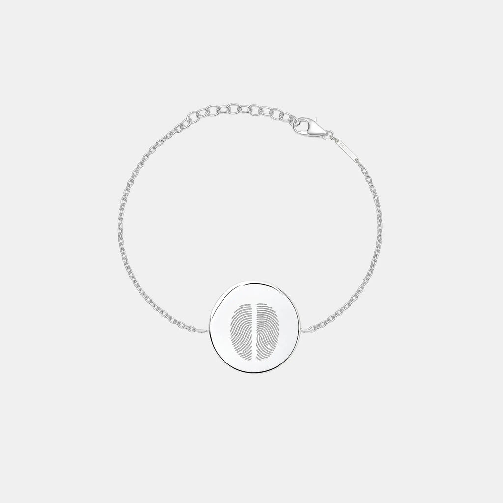 Minimal studio shot of the Atelier By DSGN Two Fingerprint Coin Bracelet in 925 Sterling Silver, featuring a polished 16mm round pendant engraved with two fingerprints and an adjustable diamond-cut chain for a refined, personal look.