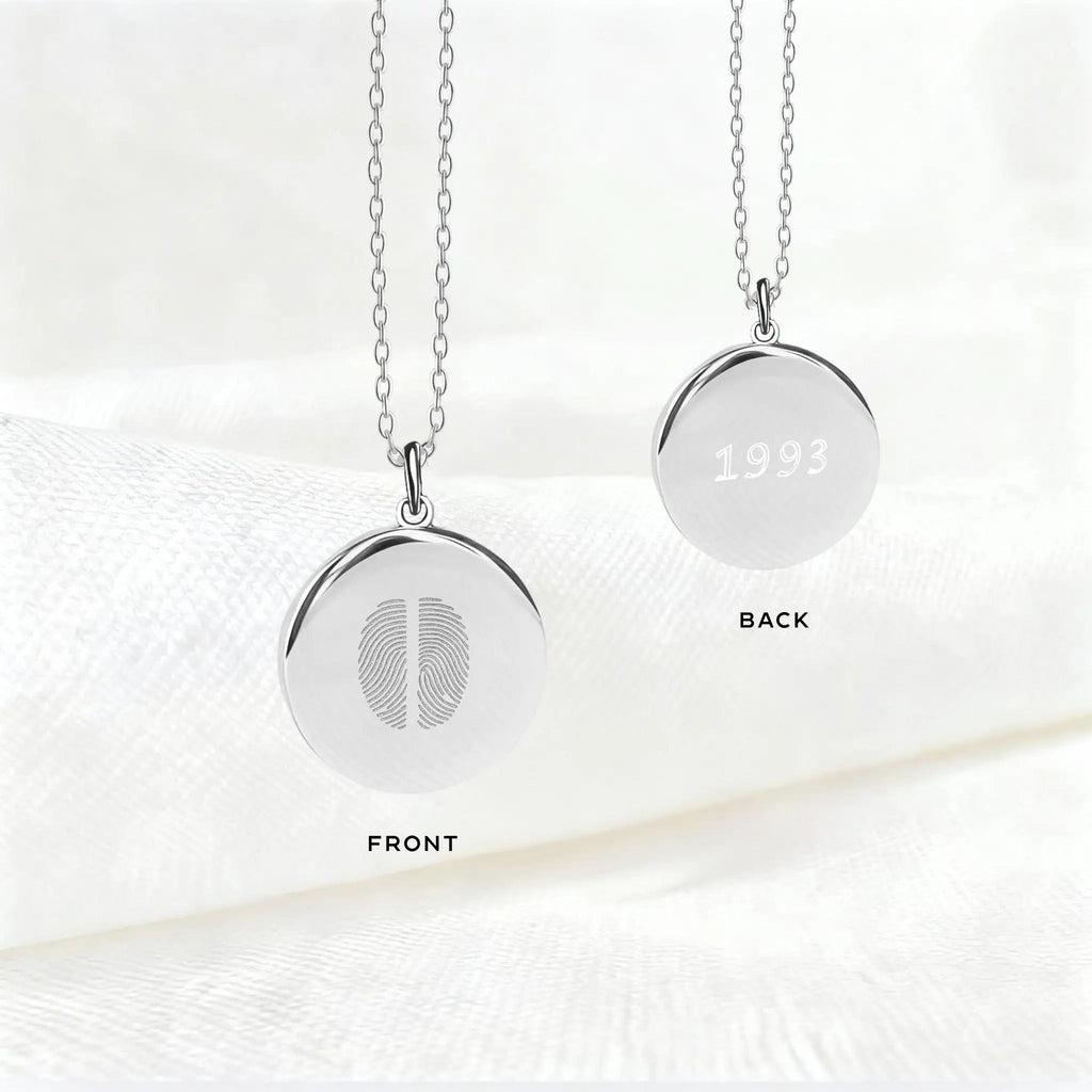 Front and back view of the Atelier Two Fingerprint Pendant Necklace in 925 Sterling Silver, featuring two engraved fingerprints on one side and personalized engraving with the year “1993” on the reverse — a timeless, custom keepsake.