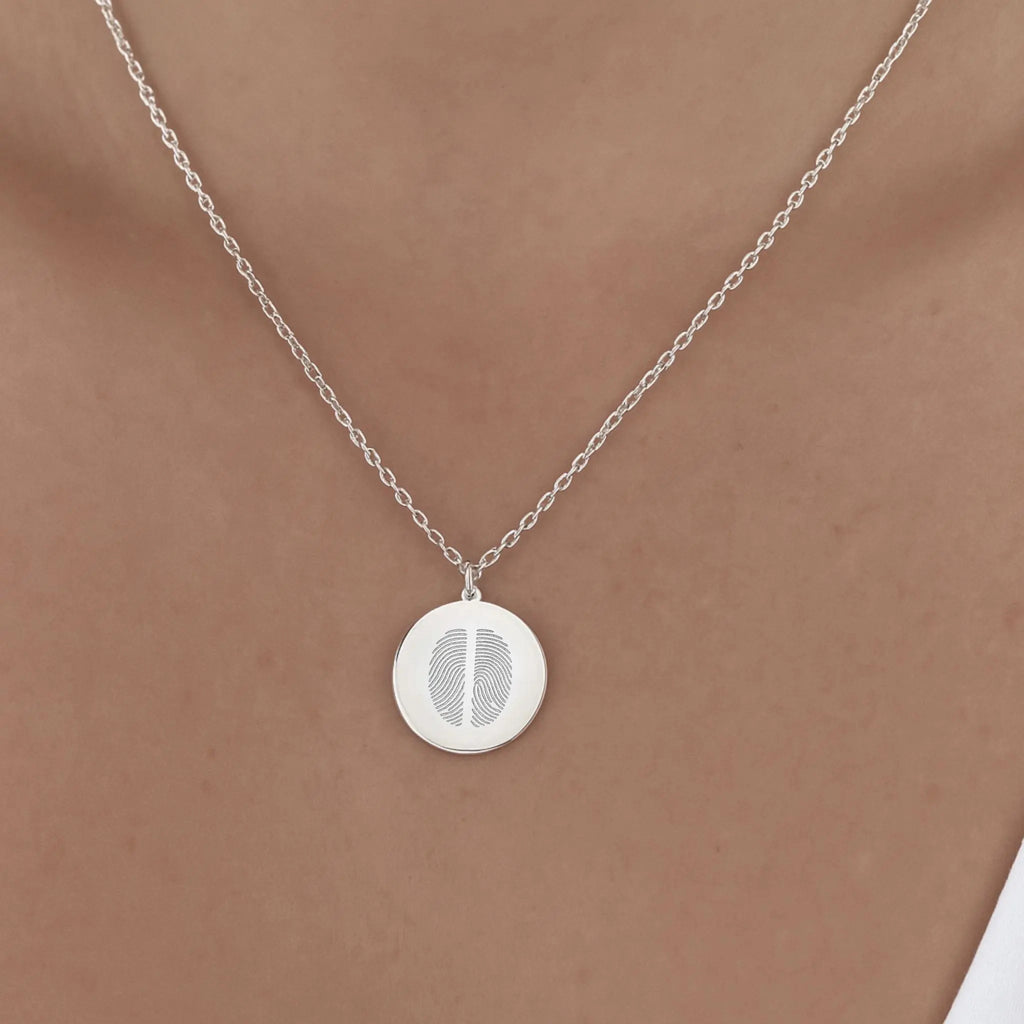 Model wearing the Atelier Two Fingerprint Pendant Necklace in 925 Sterling Silver, featuring two engraved fingerprints on a polished coin pendant that rests gracefully on the collarbone, a modern keepsake of love and connection.