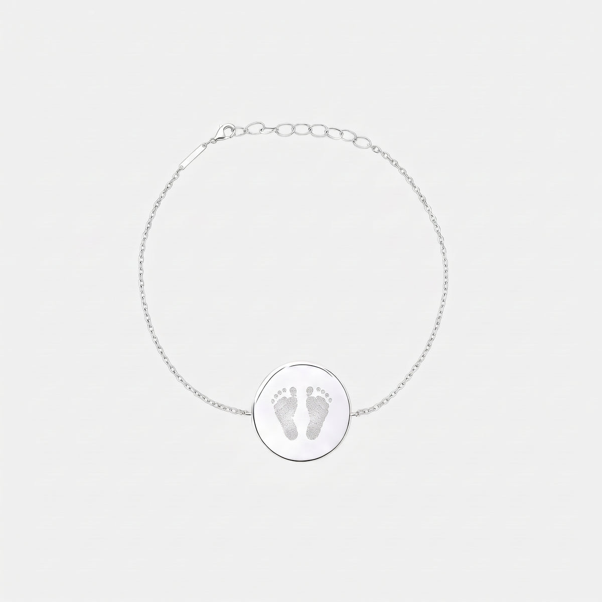 Custom engraved 925 sterling silver adjustable coin bracelet, featuring a personalised two newborn baby footprints with intricate toe and sole detail precision diamond-head engraved on polished round disc on delicate diamond-cut cable chain.  Atelier By Dsgn custom footprint coin bracelet meaningful gift for new mum, mothers day, baby shower, new baby arrival or treasured newborn family keepsake bracelet