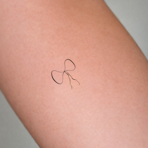 Our custom pet feature bow artwork used here as custom tattoo design on the inner arm of a lady.  Custom meaningful art from Atelier By DSGN.