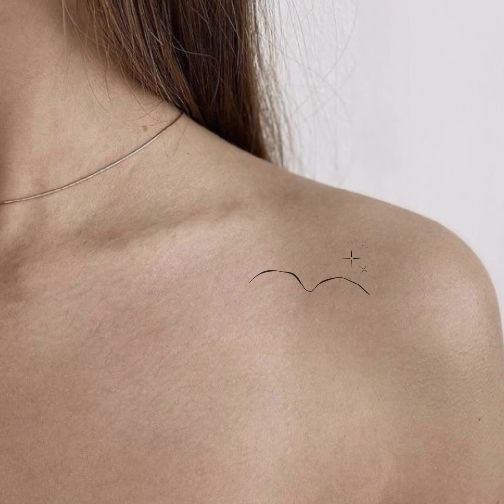 Minimalist fine-line collarbone tattoo inspiration featuring custom pet feature mountain line art and tiny accent stars.  Tiny memorial art from Atelier By DSGN.