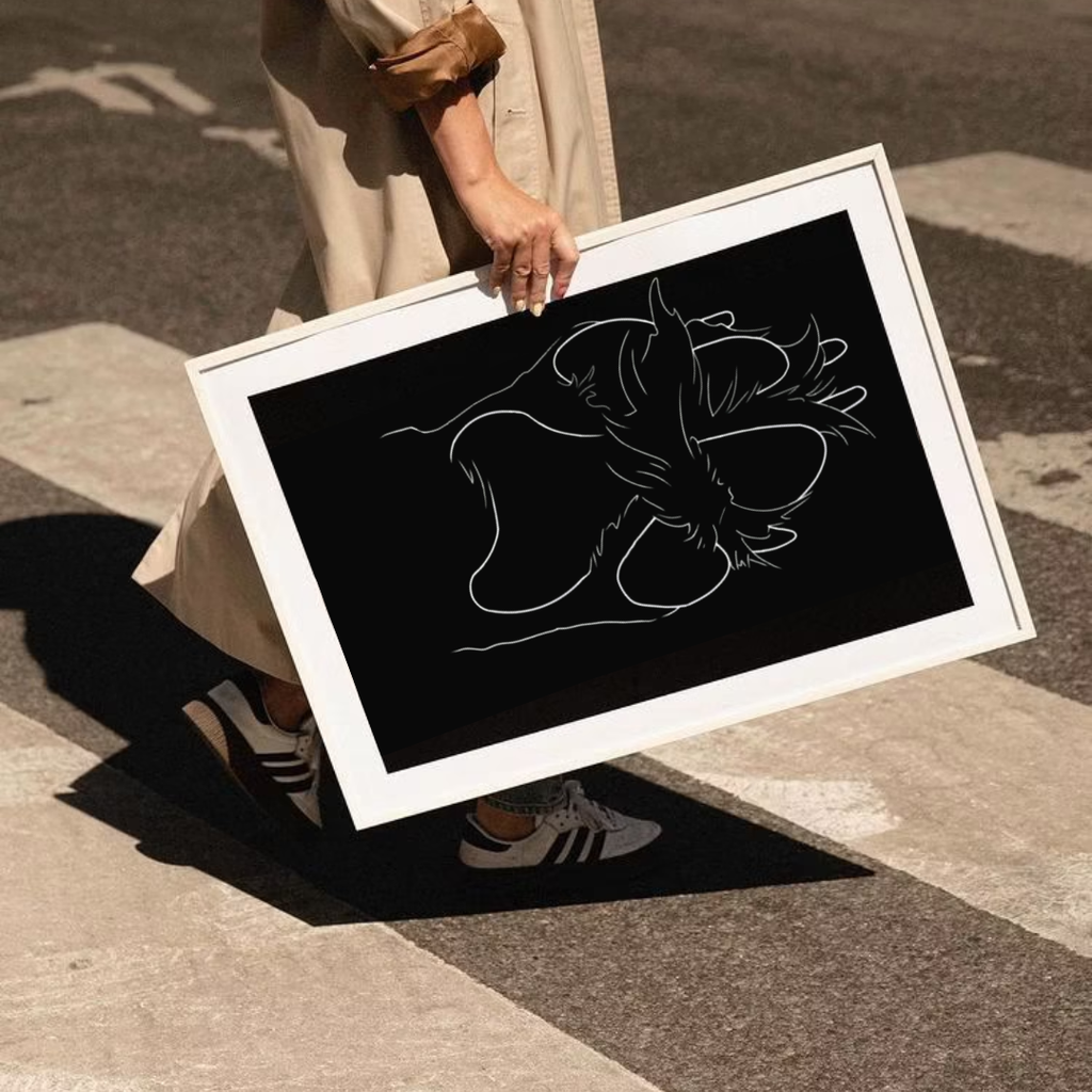 Woman carrying framed custom single line drawing art of a dog, white on black minimalist pet portrait print, personalised pet gift idea