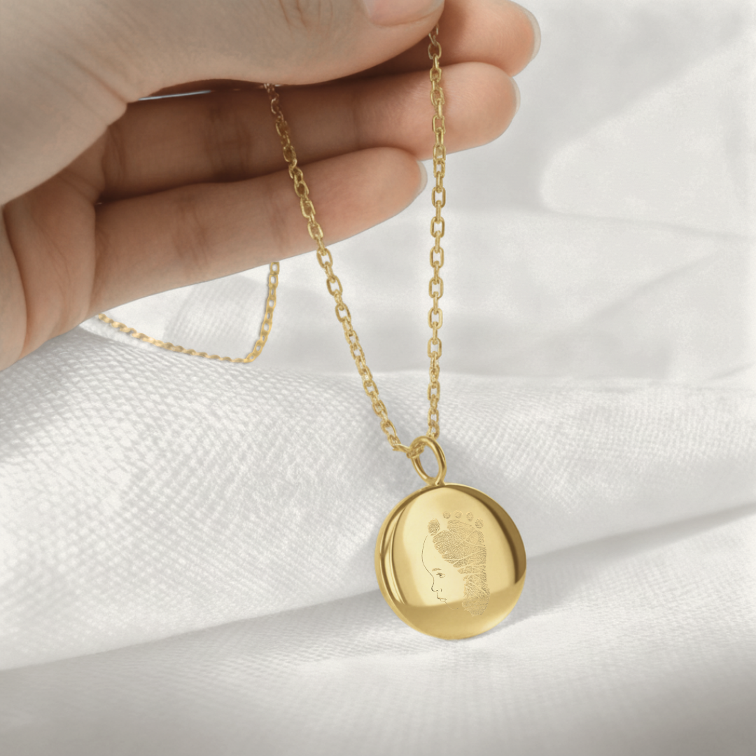 Hand holding custom single line drawing and baby footprint coin necklace in 18k gold vermeil -personalised new mum keepsake jewellery gift