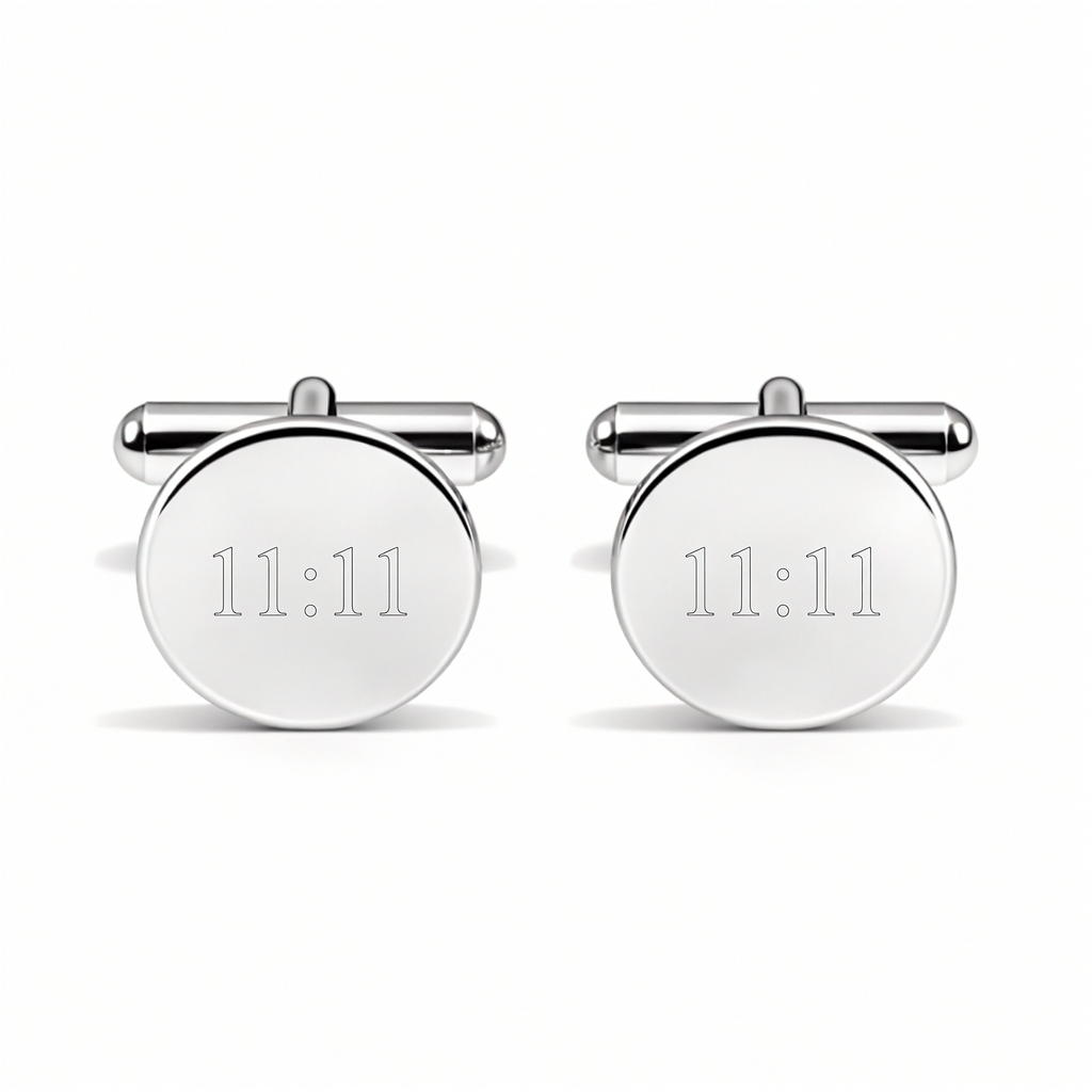 A close up of a pair of round stirling silver custom engraved cufflinks with 11:11 on them against a white back ground.