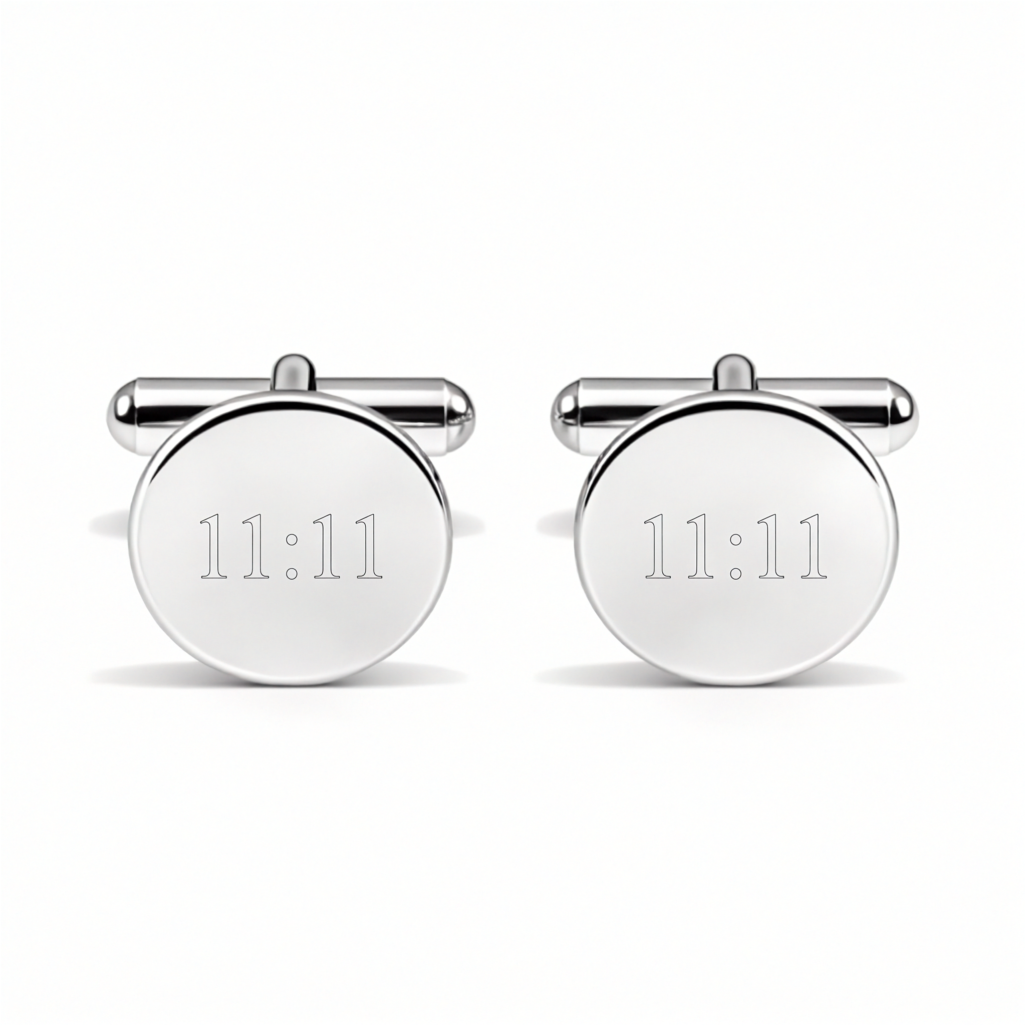 A close up of a pair of round stirling silver custom engraved cufflinks with 11:11 on them against a white back ground.