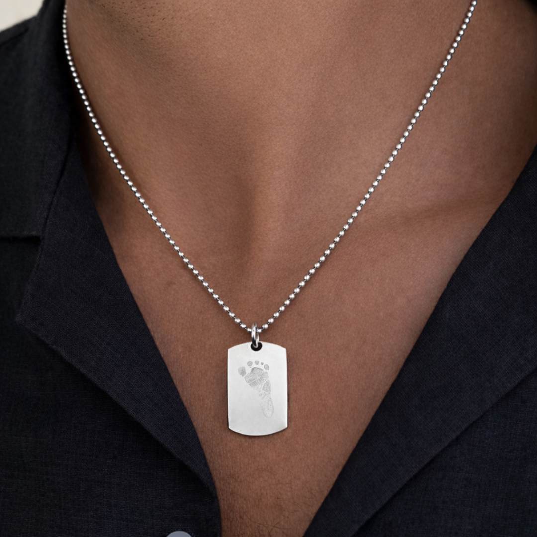 Custom Atelier By DSGN in 925 sterling silver foot print dog tag pendant around a model's neck.