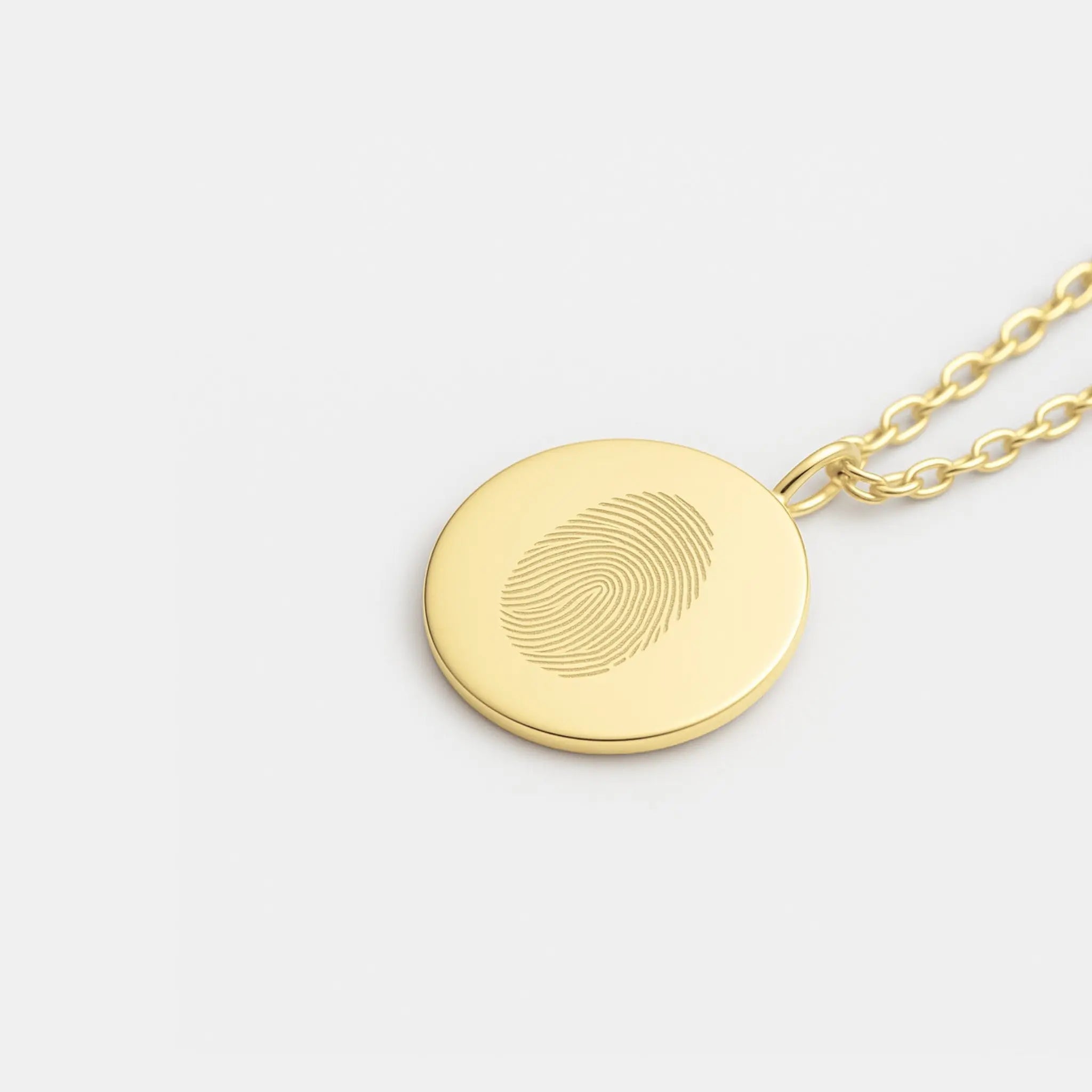 Close-up of Atelier By DSGN  single fingerprint coin necklace in 18k gold vermeil showcasing intricate design and luxurious finish.