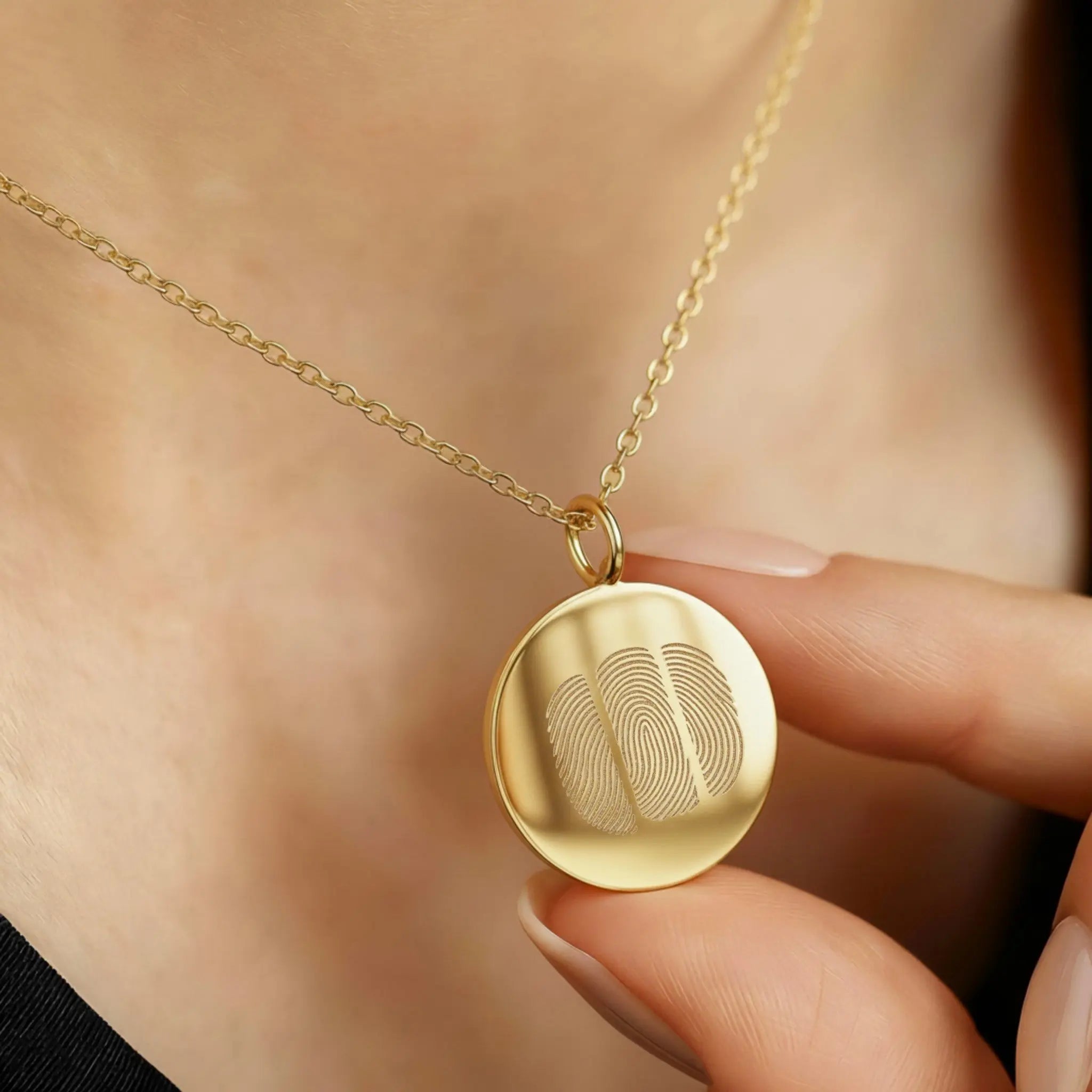 The Luxury Three Fingerprint Coin Necklace in 18K Gold Vermeil by Atelier By DSGN, shown worn close to the heart. The pendant features three finely engraved fingerprints symbolising love and connection, crafted from radiant gold vermeil for a timeless, heirloom-quality finish.