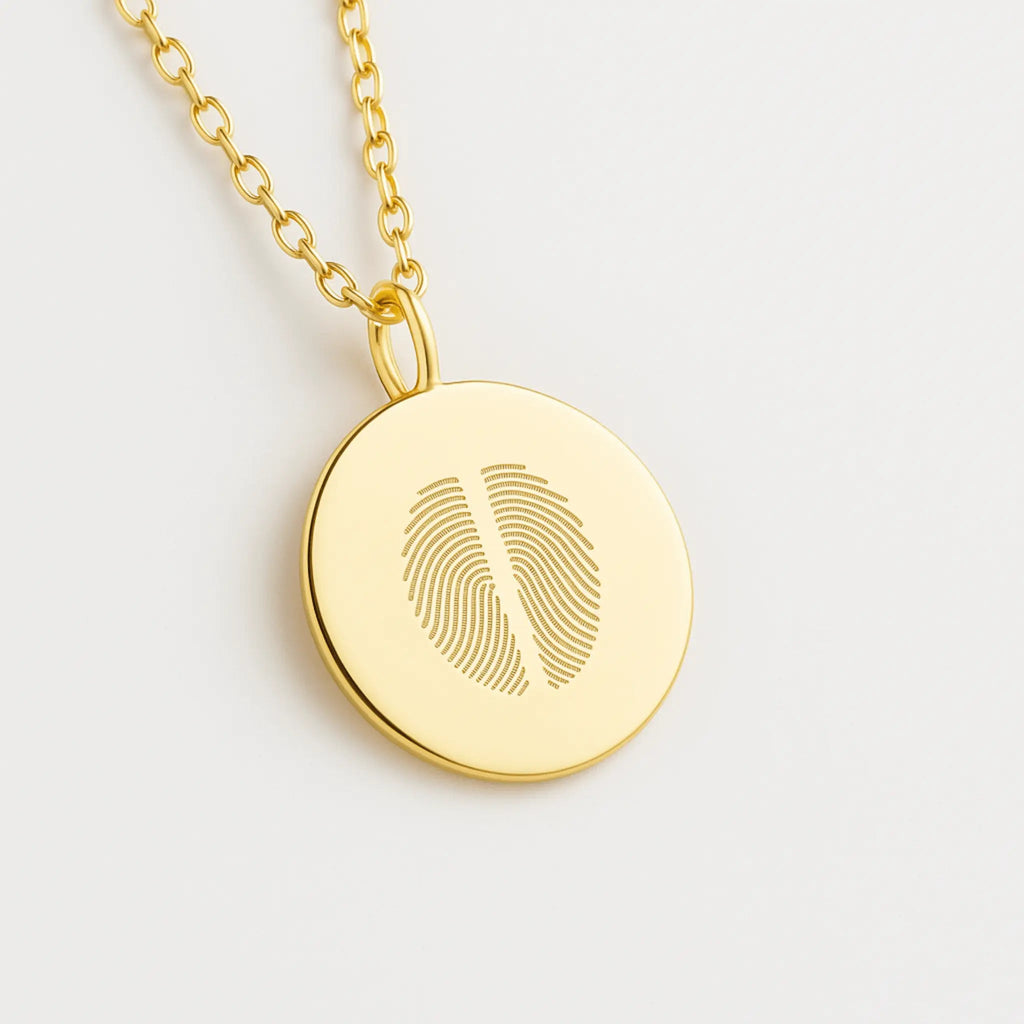Close-up of the Two Fingerprint Coin Necklace in 18k Gold Vermeil by Atelier By DSGN personalized jewelry with dual engraved fingerprints on a polished gold pendant.