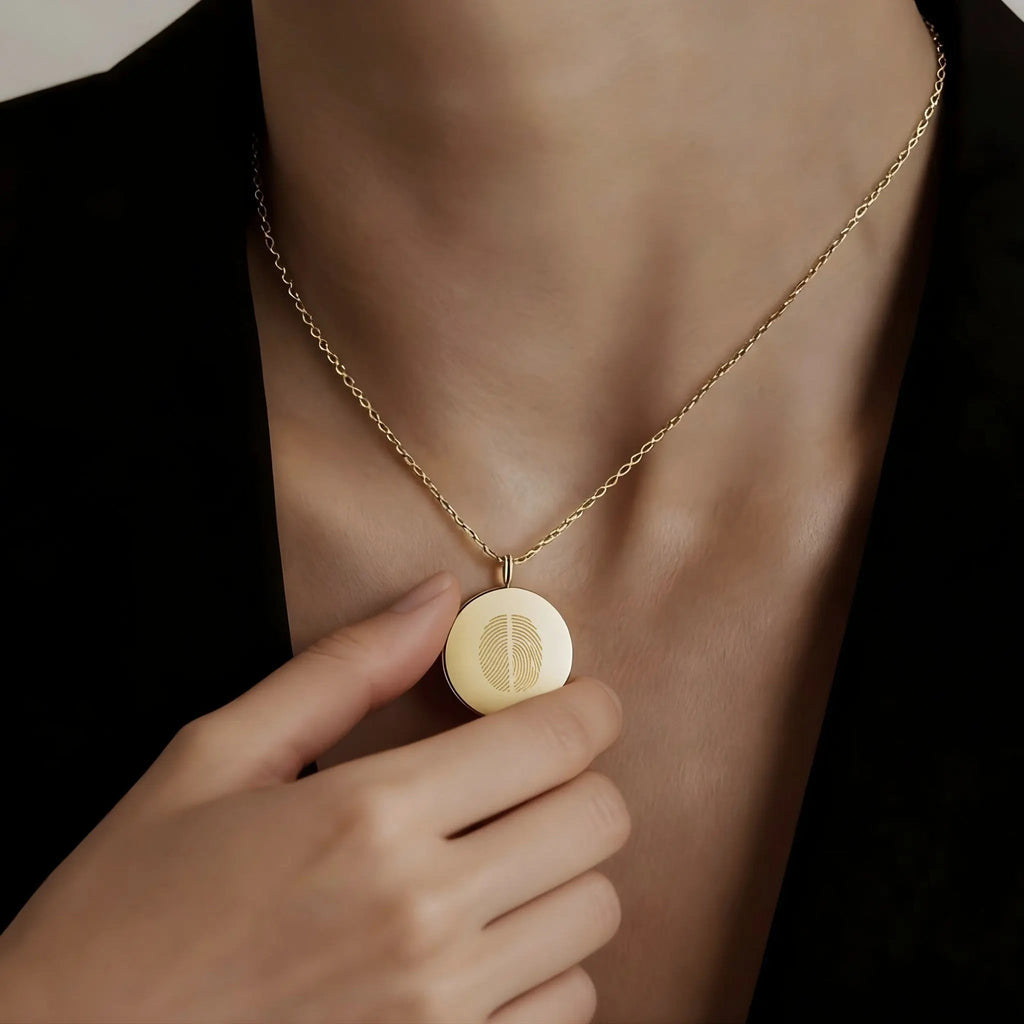 Elegant model wearing the Two Fingerprint Coin Necklace in 18k Gold Vermeil by Atelier By DSGN, luxury personalized fine jewelry featuring dual engraved fingerprints on a radiant gold pendant.