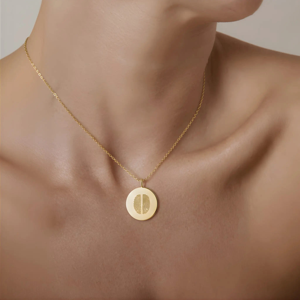 Model wearing the Two Fingerprint Coin Necklace in 18k Gold Vermeil by Atelier By DSGN a luxury personalized necklace featuring two engraved fingerprints on a polished gold 